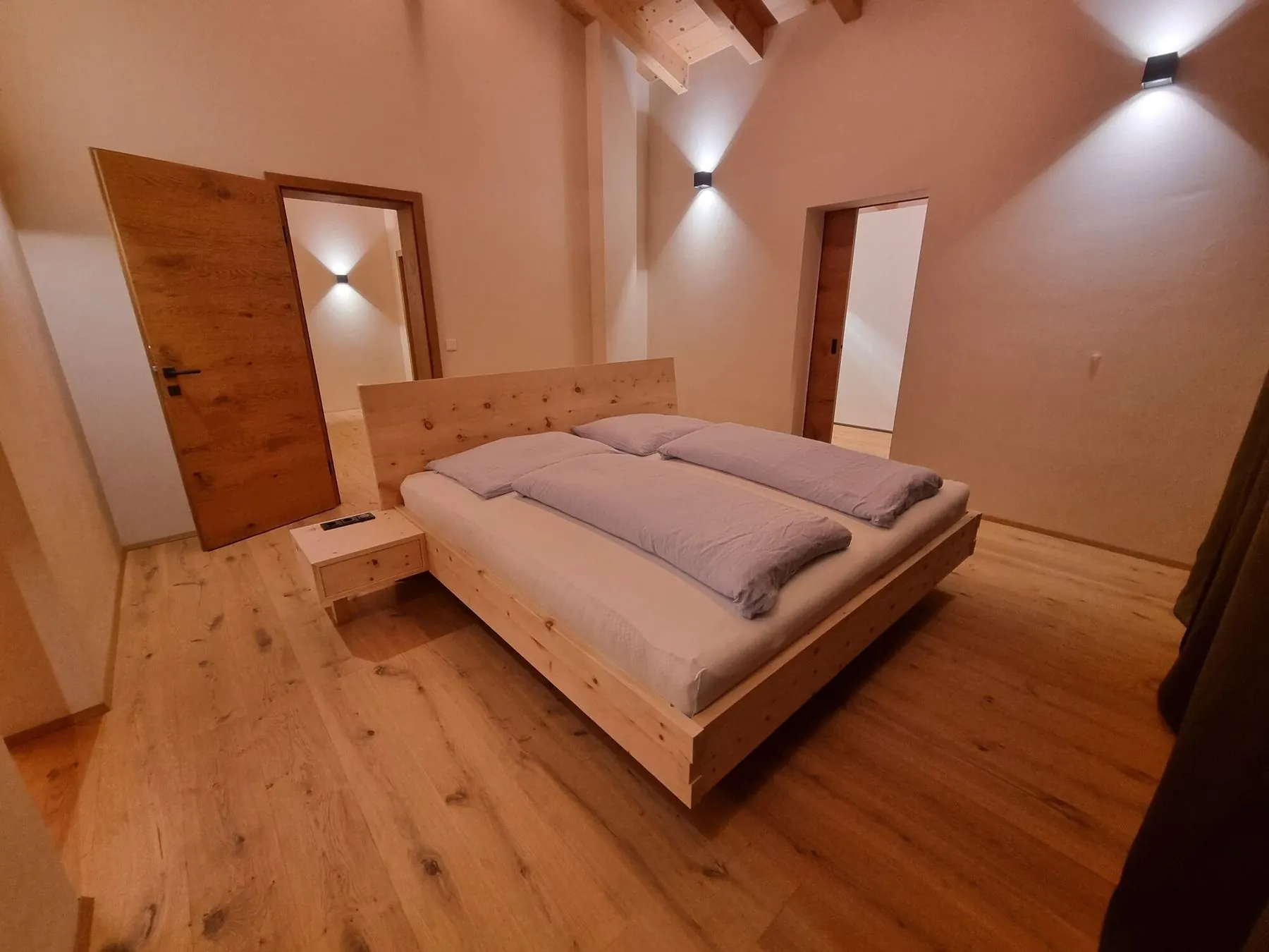 Schlafzimmer mit Zirbenbett und Wandleuchten