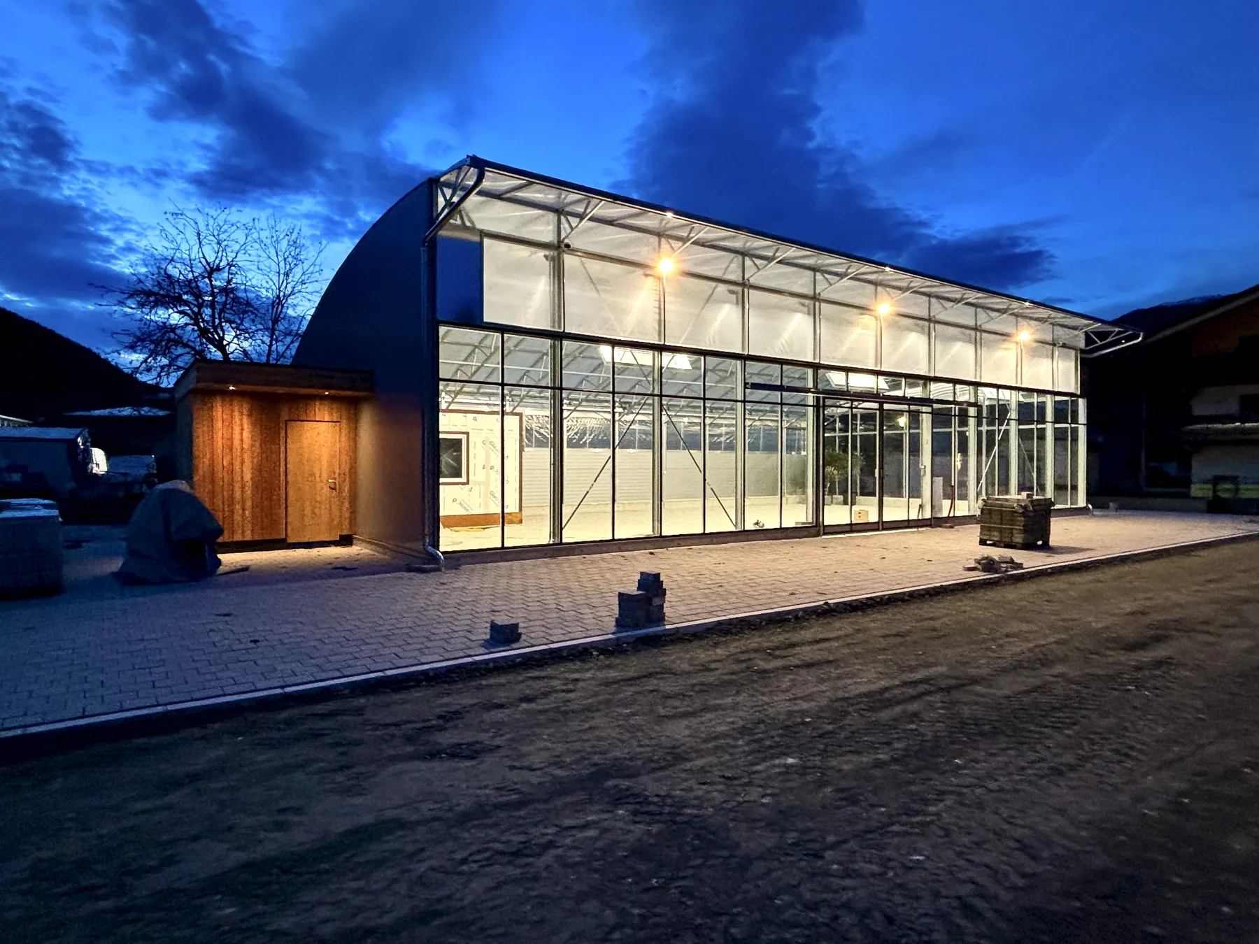 Beleuchtetes Glashaus der Keil Tauerngärten in Mittersill am Abend